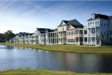 A row of houses next to a pond.