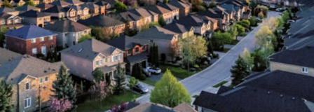 An aerial view of a residential neighborhood at sunset.