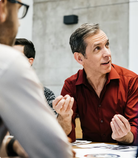 A group of people sitting around a table talking.