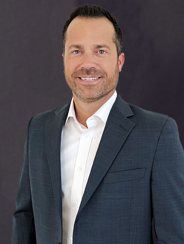 A man in a suit posing for a photo.