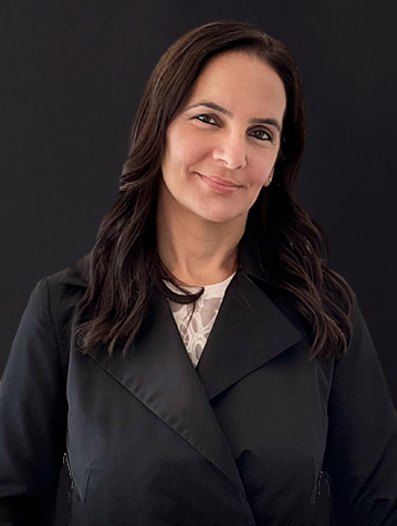 A woman in a black coat smiling for the camera.