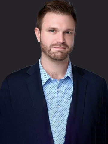 A man in a suit is standing in front of a dark background.