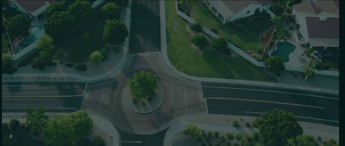 Aerial view of a roundabout at the intersection of several roads in a suburban area.